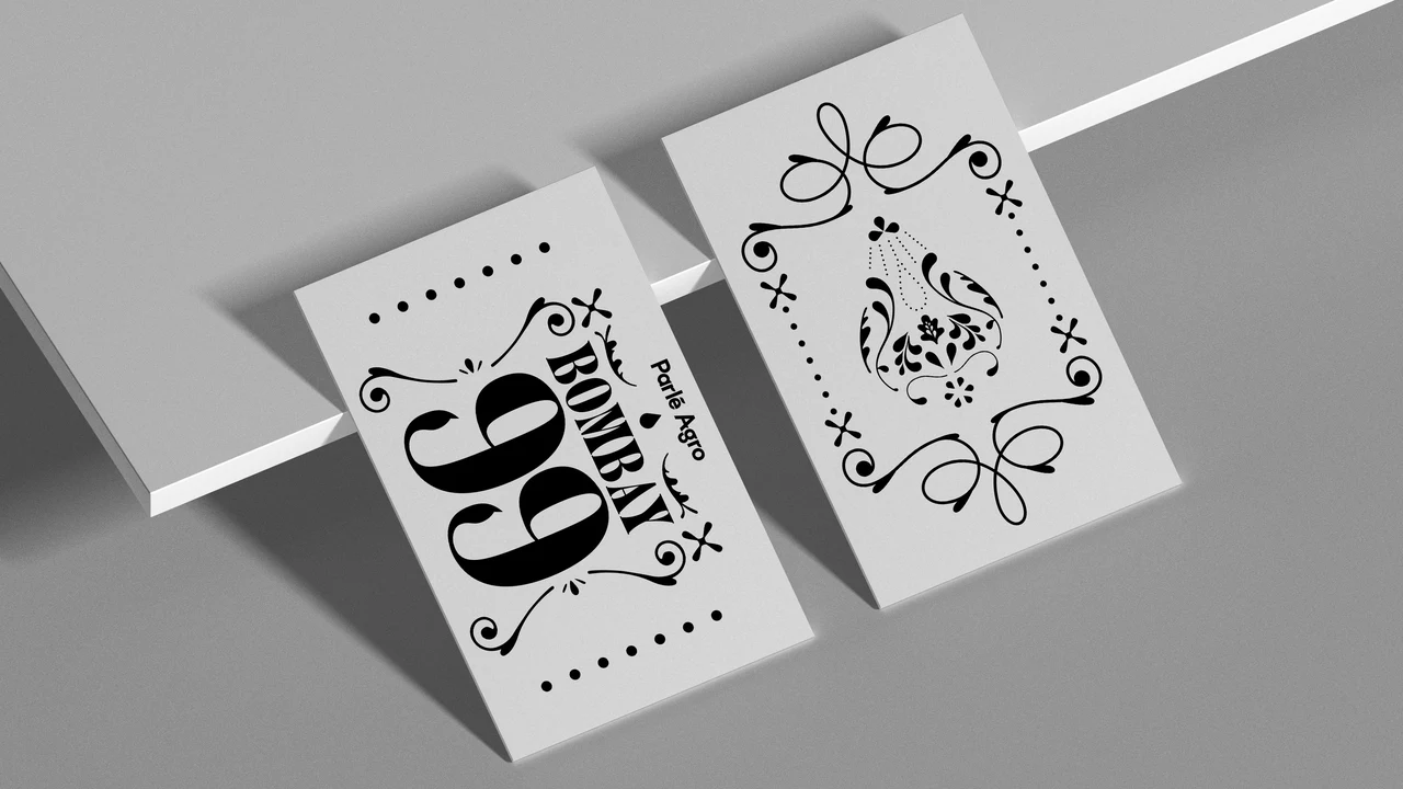 Two angled white cards display Bombay 99 in black typography and a symmetrical arrangement of droplet-inspired ornaments.