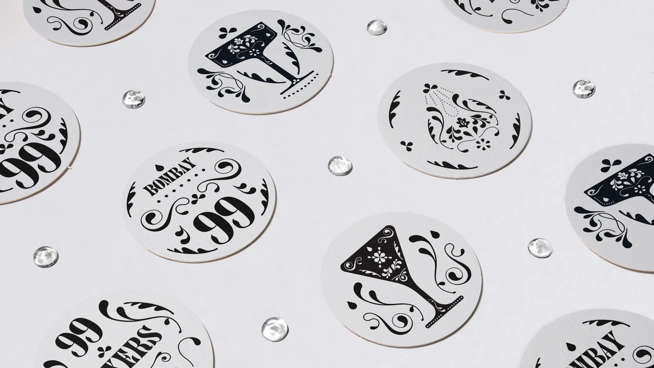 White circular coasters scattered among transparent droplets alternate the Bombay 99 name, goblets and black ornamental drawings.