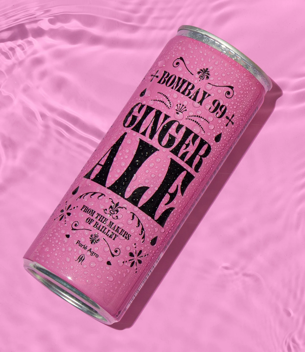 Pink Ginger Ale can floats in pink water, with ripples, reflections and condensation droplets on the package.