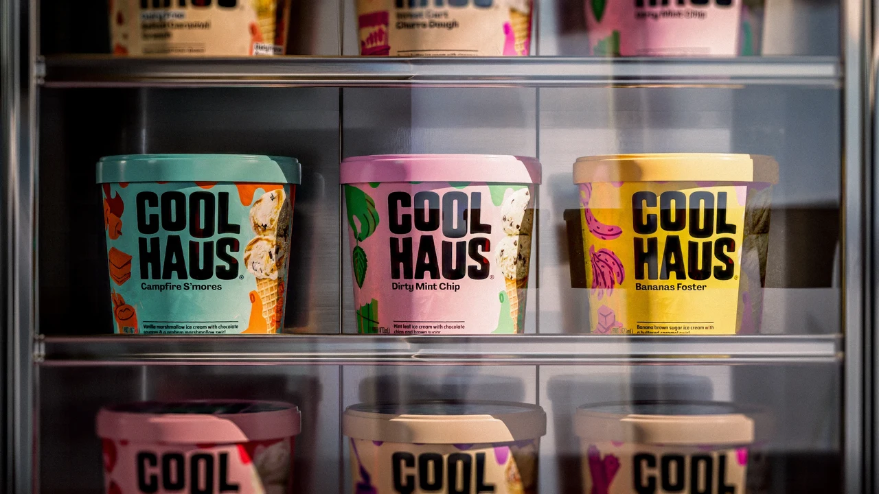 Coolhaus tubs in blue, pink and yellow fill shelves in a glass-door freezer, demonstrating the packaging system at retail.