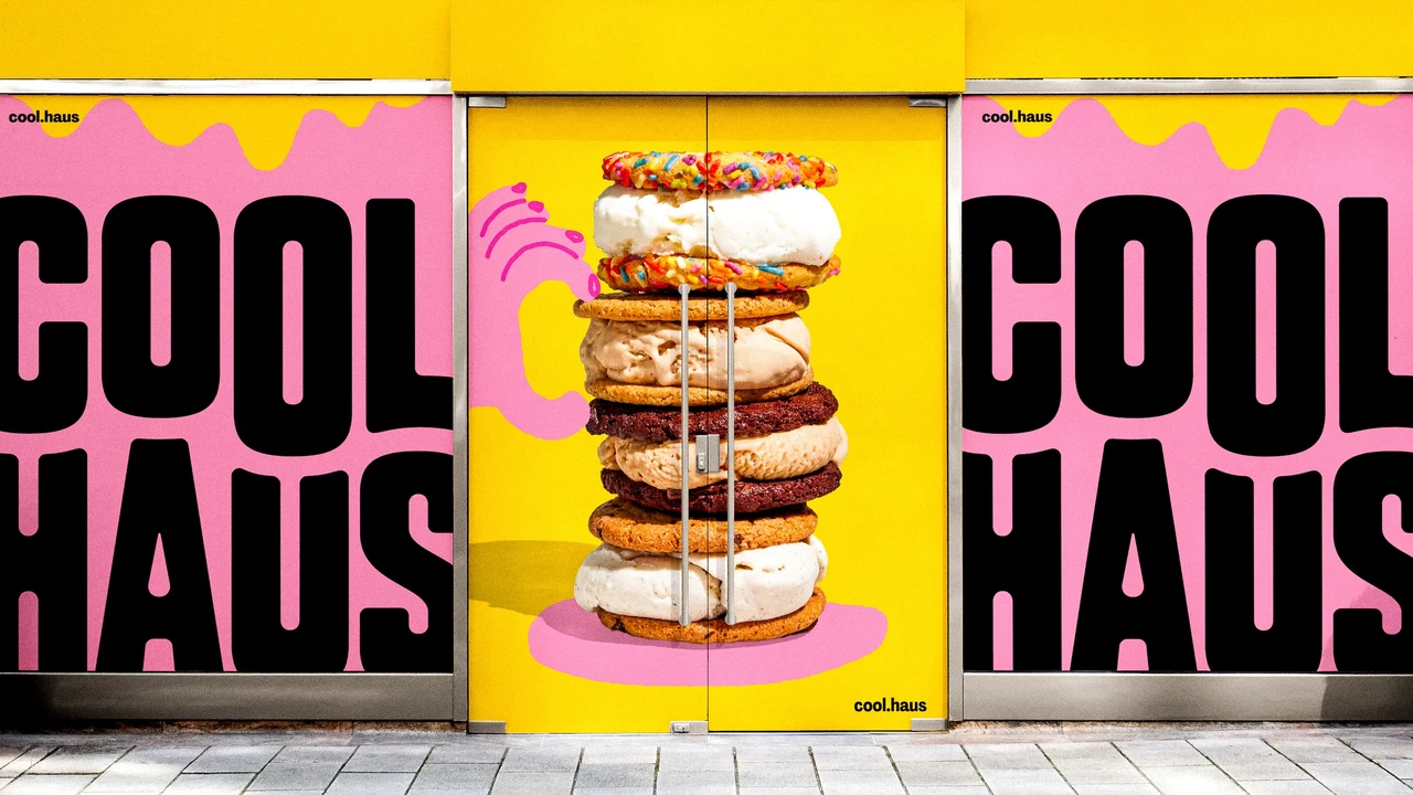Storefront covered with pink and yellow panels featuring enlarged Coolhaus branding, drips and a central stack of ice cream sandwiches.