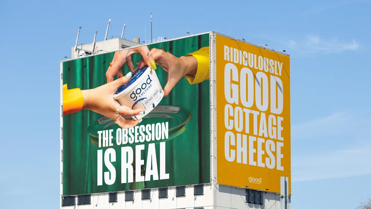 Two faces of a large urban billboard show hands holding a cottage cheese tub and tall white lettering on green and yellow backgrounds.