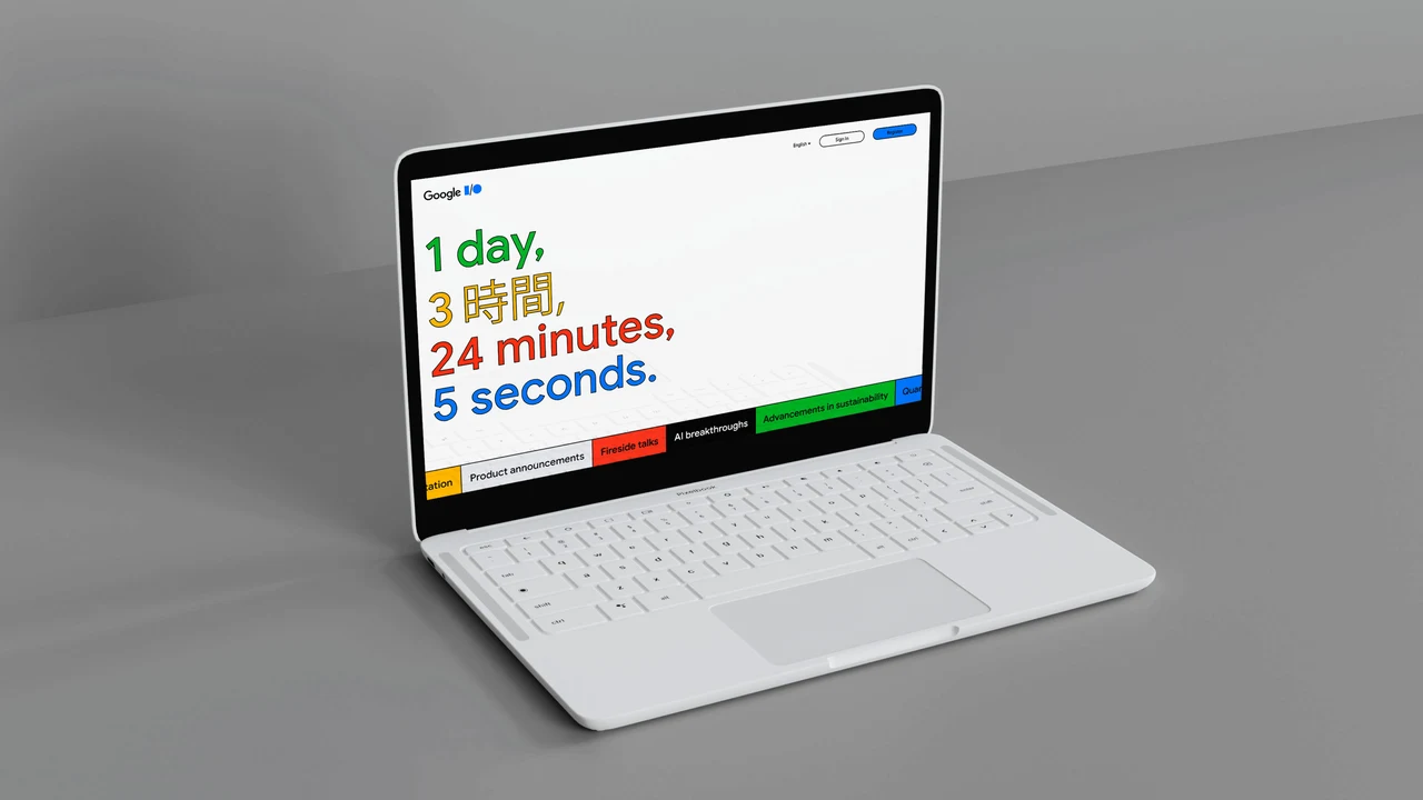Notebook branco apresenta uma página Google I/O com contagem regressiva multicolorida e multilíngue, cabeçalho discreto e faixa de navegação colorida na base.