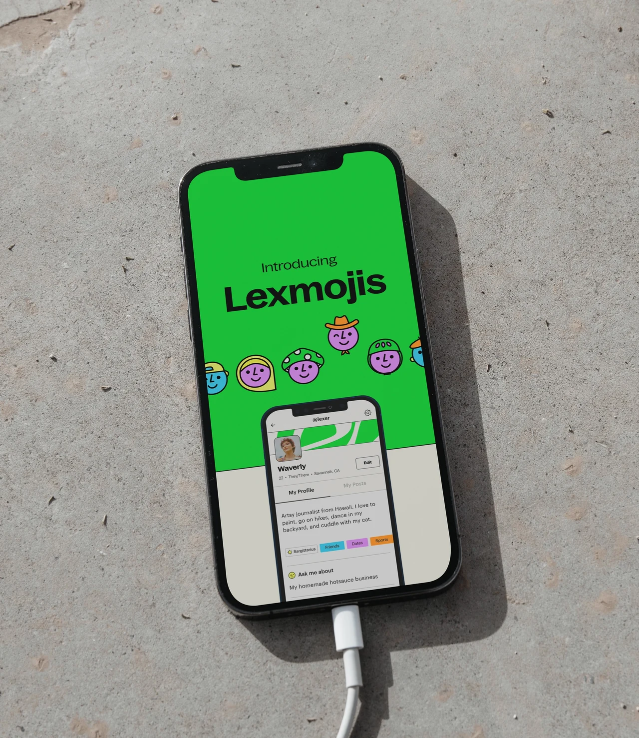 A phone connected to a cable presents a green Lexmojis page with a row of illustrated characters and an app interface preview.