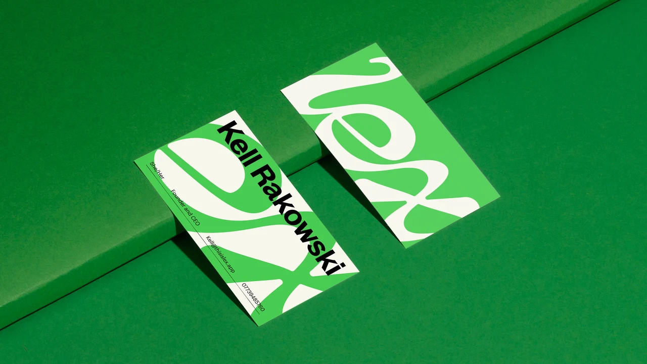 Green and cream Lex business cards rest on a green surface, alternating oversized letterforms with Kelli Rakowski’s name in black.