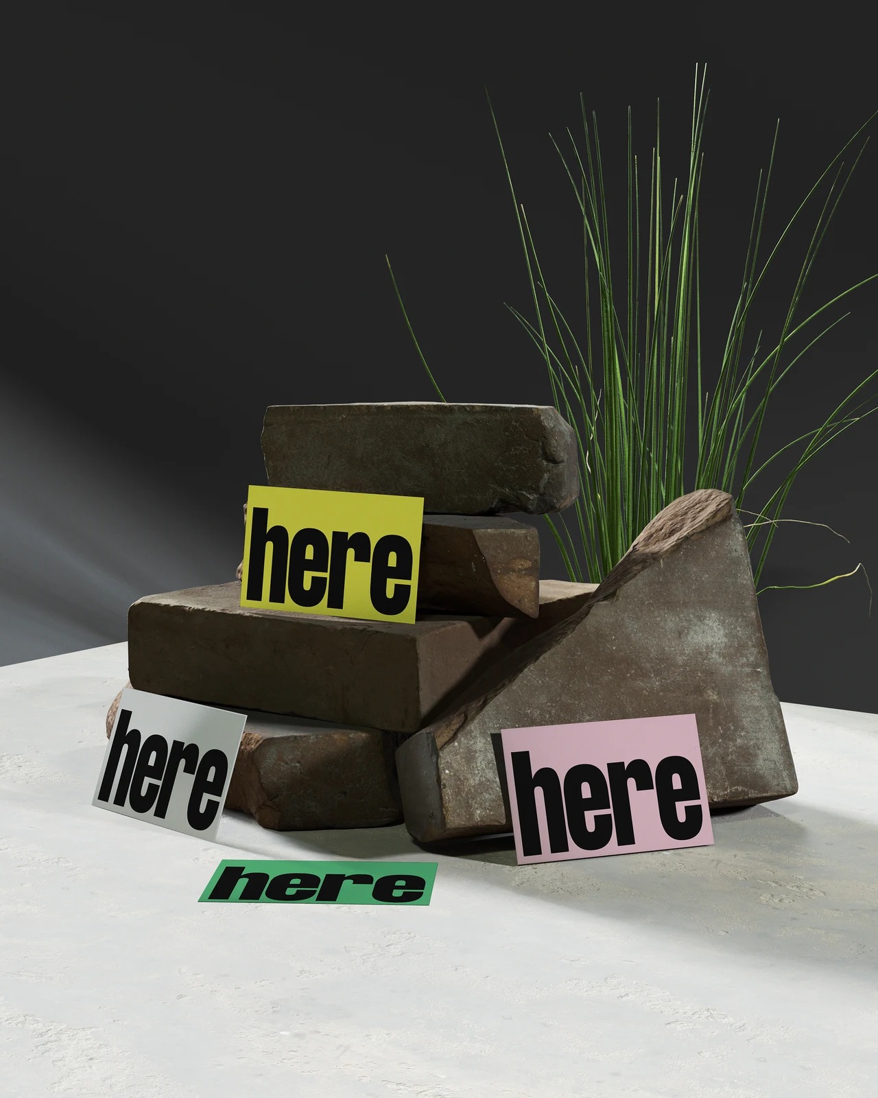 A textured arrangement of stacked stones and vegetation features yellow, white, pink and green here cards in a dark setting.
