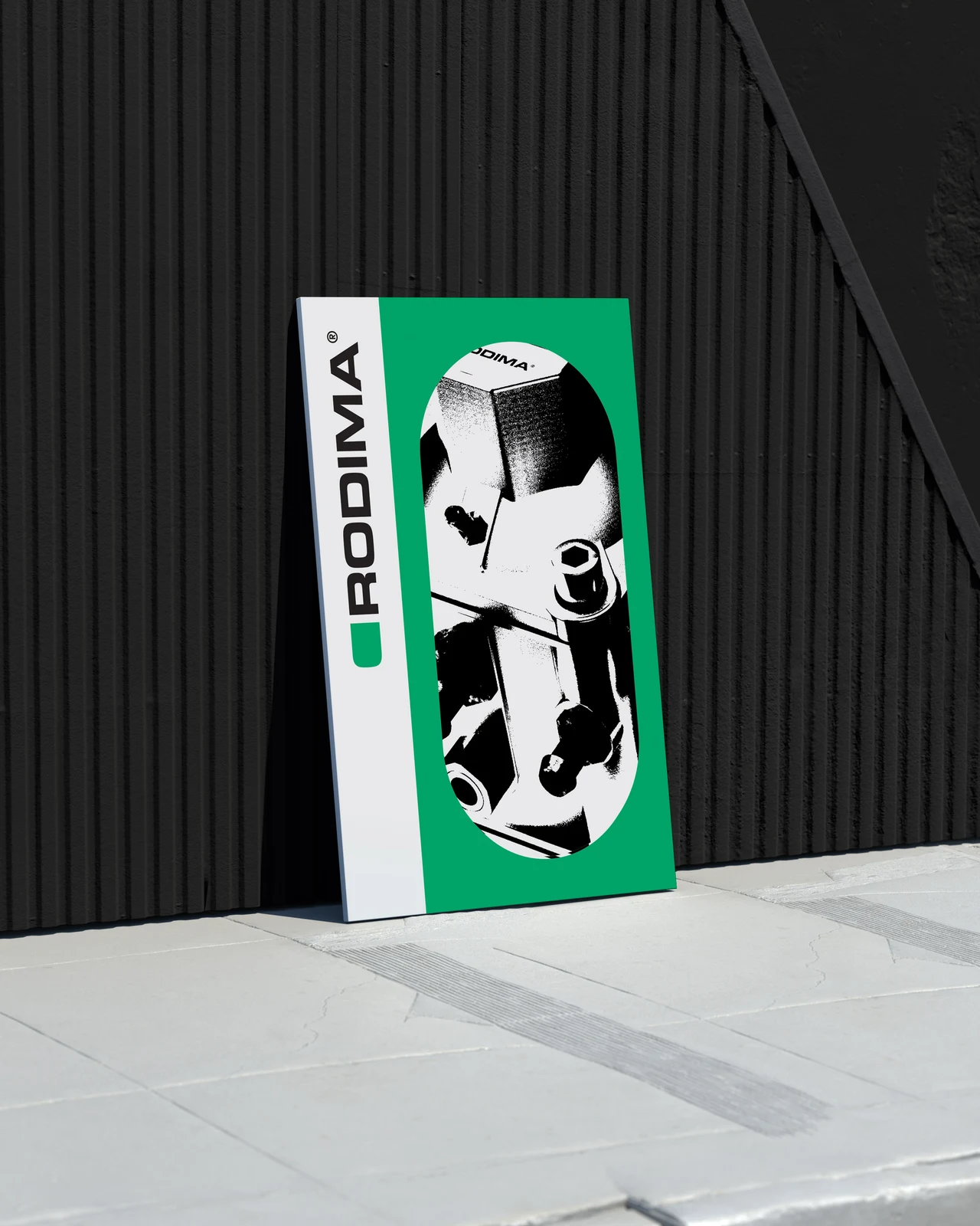 A green and white vertical Rodima board features a cropped automotive component against a black ribbed wall.