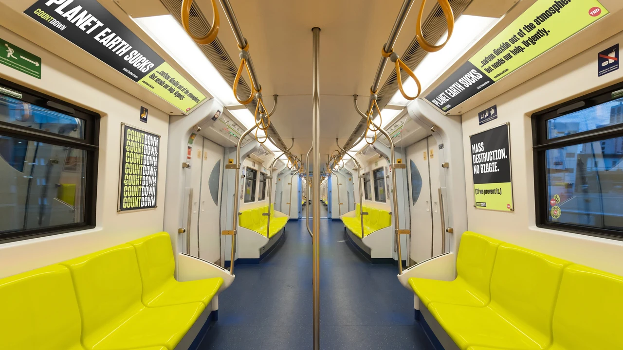 Train interior with yellow seats carries Countdown advertisements above the windows and on the walls in condensed black and white typography.