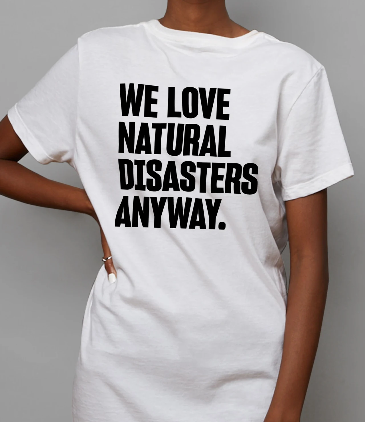 Front view of a white T-shirt displays We love natural disasters anyway in tall condensed black letters.
