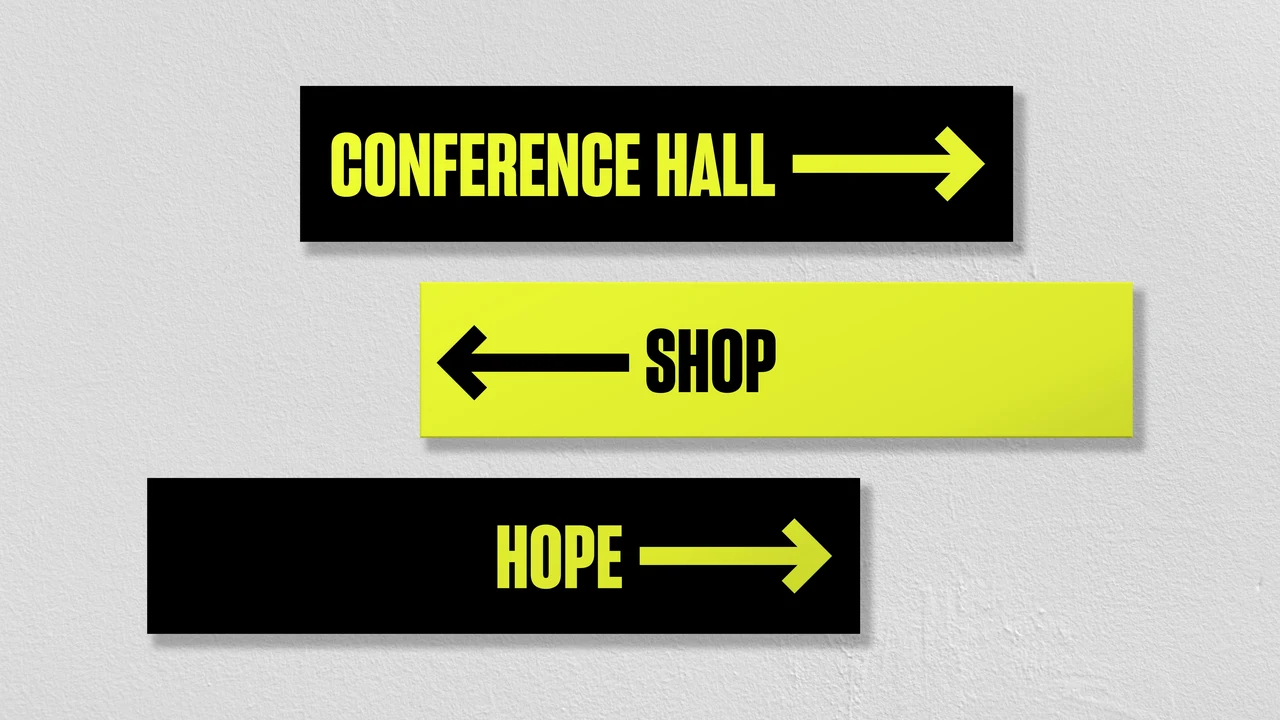 Rectangular wayfinding signs alternate black and lime-yellow backgrounds, with arrows and the labels Conference hall, Shop and Hope.
