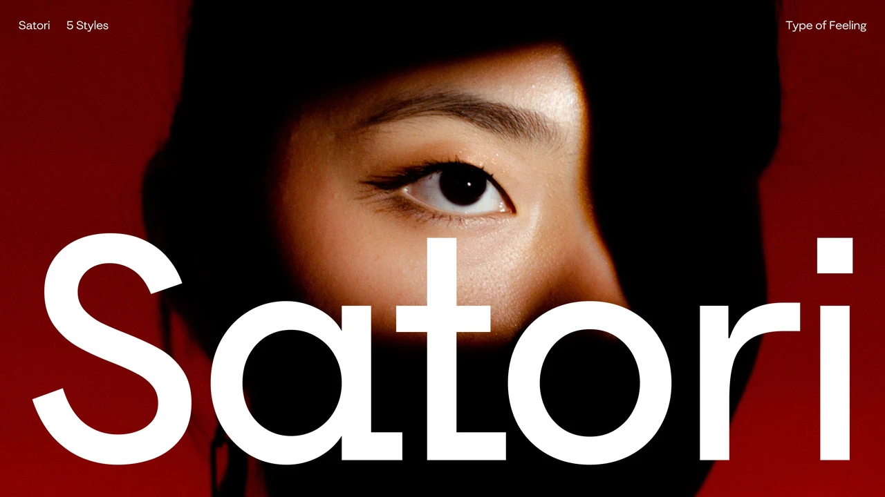 Satori specimen places rounded white lettering over a partial portrait with one illuminated eye, dark hair and a red background.